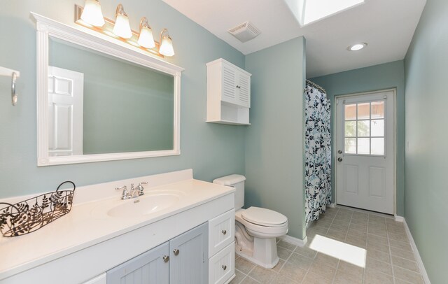 bathroom with tile patterned flooring, vanity, walk in shower, and toilet