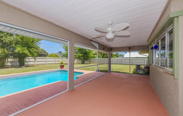 view of swimming pool with ceiling fan, a patio, and a lawn