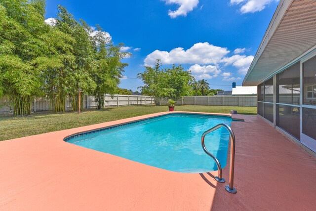 view of swimming pool featuring a lawn and a patio