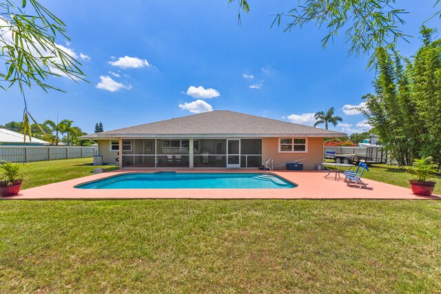 view of swimming pool with a sunroom, a patio area, and a lawn