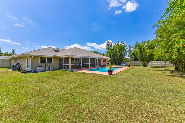 back of property featuring a yard, a fenced in pool, a sunroom, and central air condition unit