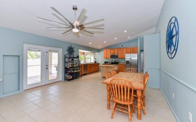 tiled dining space with lofted ceiling, french doors, and ceiling fan