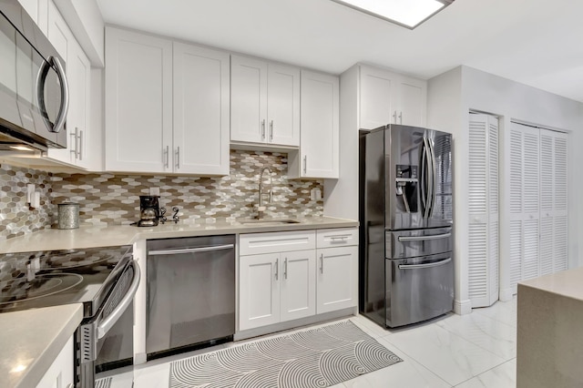 kitchen with white cabinets, appliances with stainless steel finishes, decorative backsplash, and sink