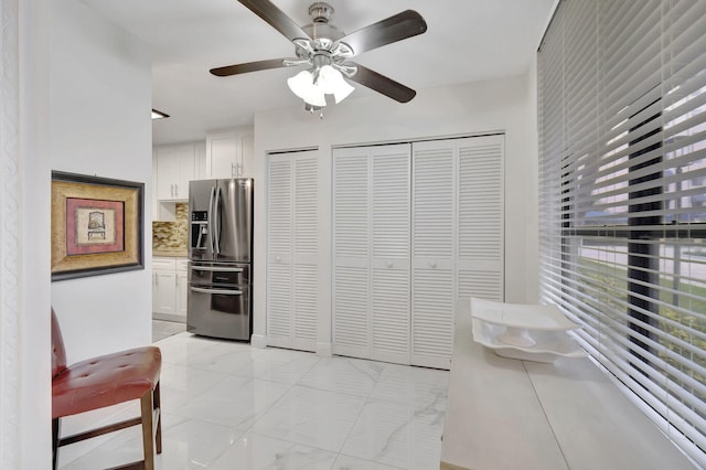 kitchen with decorative backsplash, white cabinets, and stainless steel refrigerator with ice dispenser