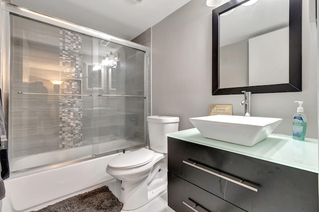 full bathroom with toilet, vanity, and combined bath / shower with glass door