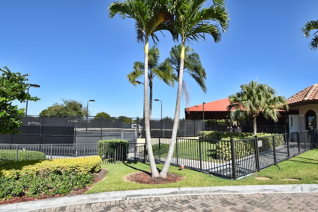 view of community featuring a yard and tennis court