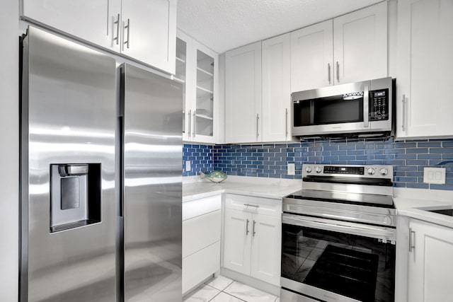 kitchen with backsplash, appliances with stainless steel finishes, and white cabinetry