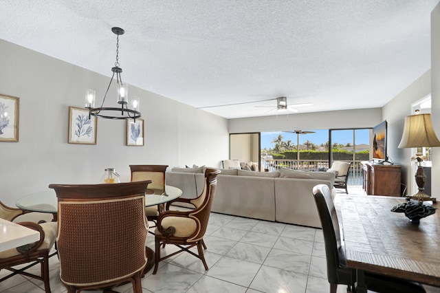 tiled dining room featuring a textured ceiling and ceiling fan with notable chandelier