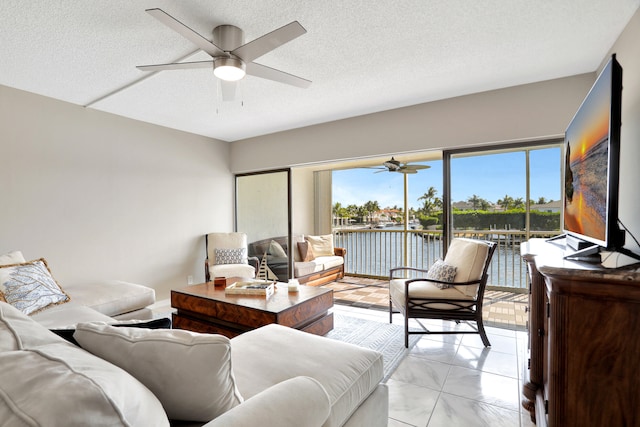 living room featuring plenty of natural light, ceiling fan, and light tile floors