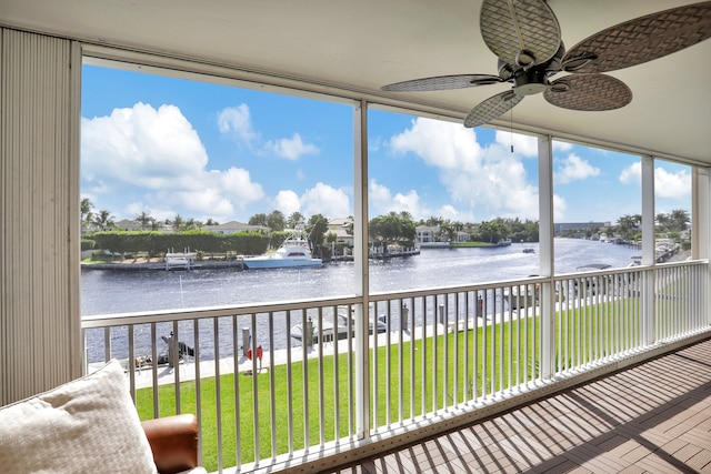 sunroom / solarium with ceiling fan and a water view