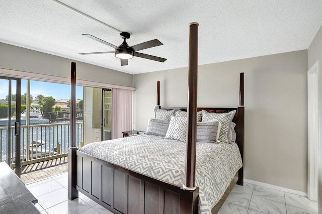 bedroom featuring a textured ceiling, ceiling fan, and light tile floors