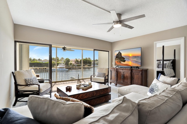 living room with a textured ceiling and ceiling fan