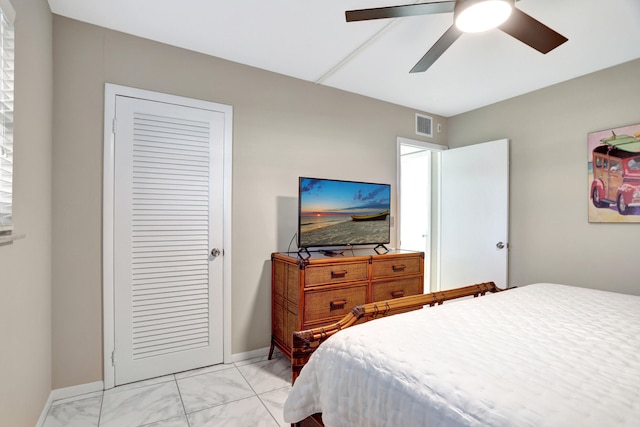 bedroom featuring a closet, ceiling fan, and light tile floors