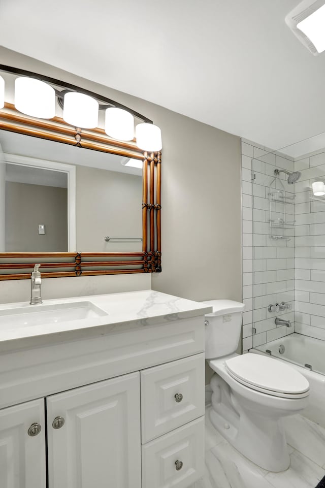 full bathroom with tiled shower / bath, tile flooring, large vanity, and toilet