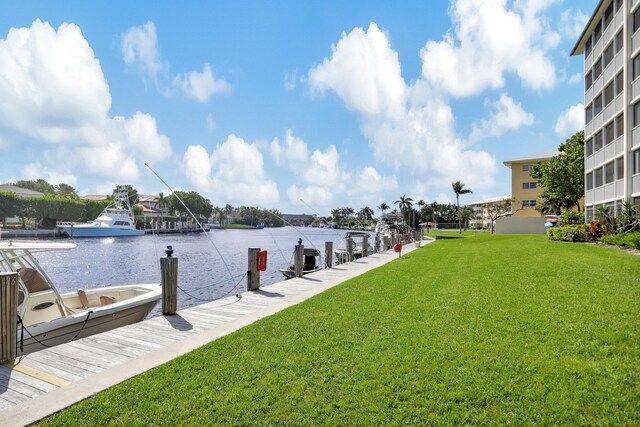 view of dock featuring a water view and a yard