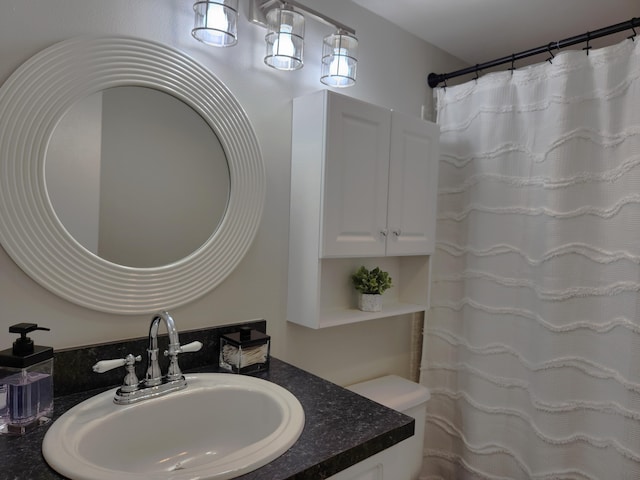 bathroom with toilet and vanity with extensive cabinet space