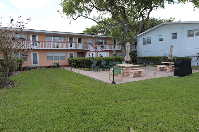 view of home's community with a patio, a fire pit, and a yard