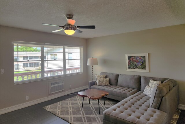 tiled living room featuring ceiling fan, a wall mounted AC, and a textured ceiling