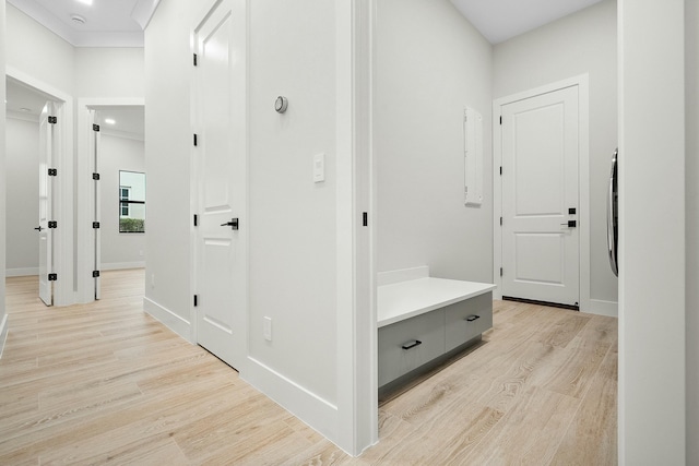 corridor featuring crown molding and light hardwood / wood-style flooring