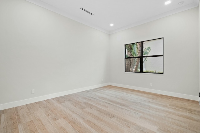 empty room featuring ornamental molding and light hardwood / wood-style flooring