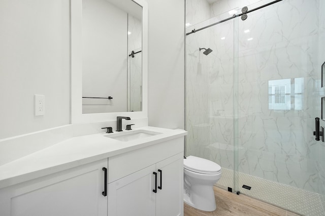 bathroom featuring toilet, an enclosed shower, vanity, and hardwood / wood-style floors