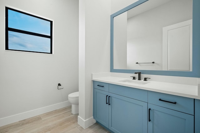 bathroom with hardwood / wood-style floors, vanity, and toilet