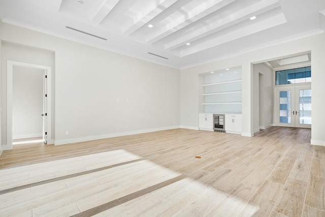 unfurnished living room with light hardwood / wood-style flooring, french doors, built in features, and crown molding