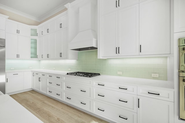 kitchen with white cabinets, stainless steel appliances, tasteful backsplash, and custom exhaust hood