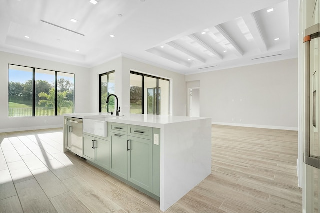 kitchen featuring dishwasher, an island with sink, a raised ceiling, crown molding, and sink