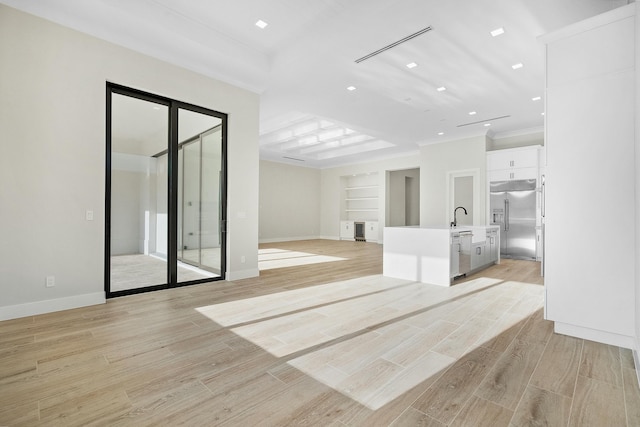 unfurnished living room featuring ornamental molding and sink