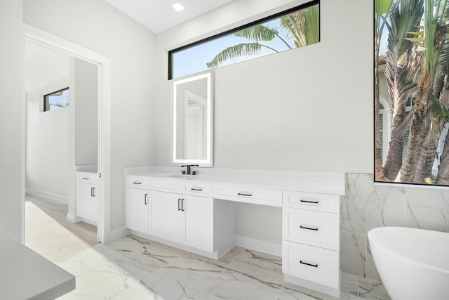 bathroom with a tub to relax in and vanity