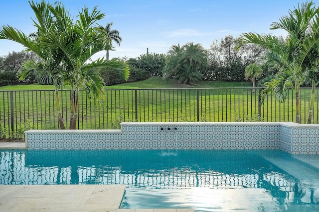 view of swimming pool featuring pool water feature and a lawn