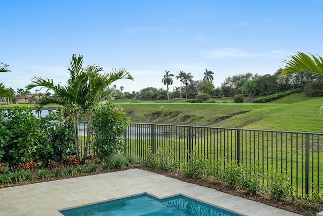 view of swimming pool featuring a patio area, a lawn, and a water view