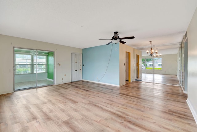 unfurnished living room with ceiling fan with notable chandelier and light hardwood / wood-style floors