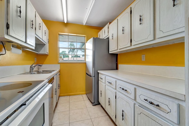 kitchen with sink, light tile patterned floors, white cabinetry, white range with electric cooktop, and stainless steel refrigerator