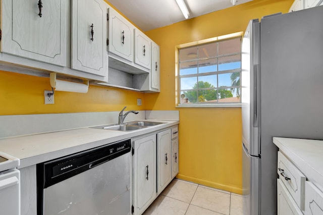 kitchen featuring sink, white cabinets, stainless steel appliances, and light tile patterned floors