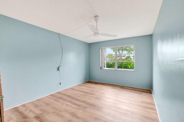 unfurnished room with ceiling fan, a textured ceiling, and light wood-type flooring