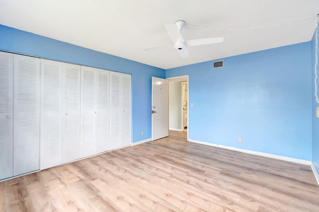 unfurnished bedroom featuring a closet, ceiling fan, light hardwood / wood-style flooring, and a textured ceiling