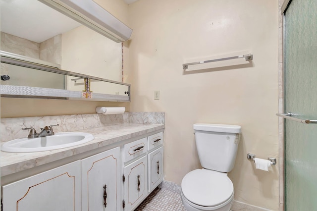 bathroom with tile patterned floors, vanity, toilet, and a shower with door