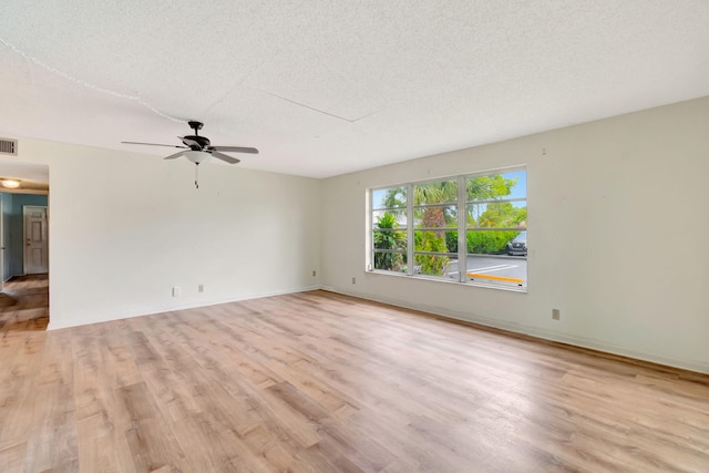 spare room with ceiling fan, light hardwood / wood-style flooring, and a textured ceiling