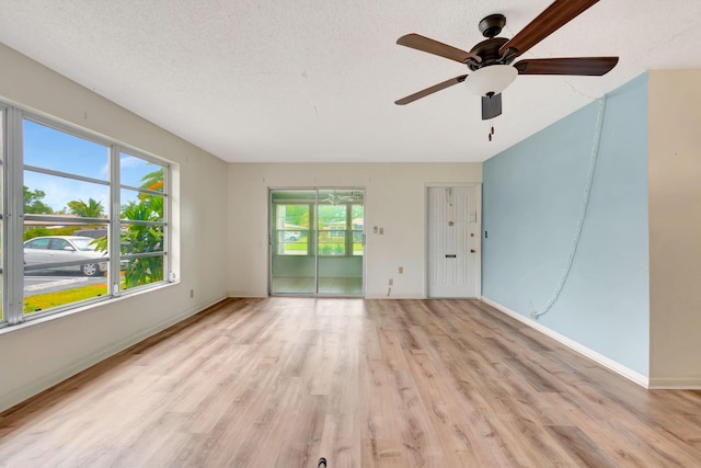 spare room with ceiling fan, light hardwood / wood-style floors, and a textured ceiling