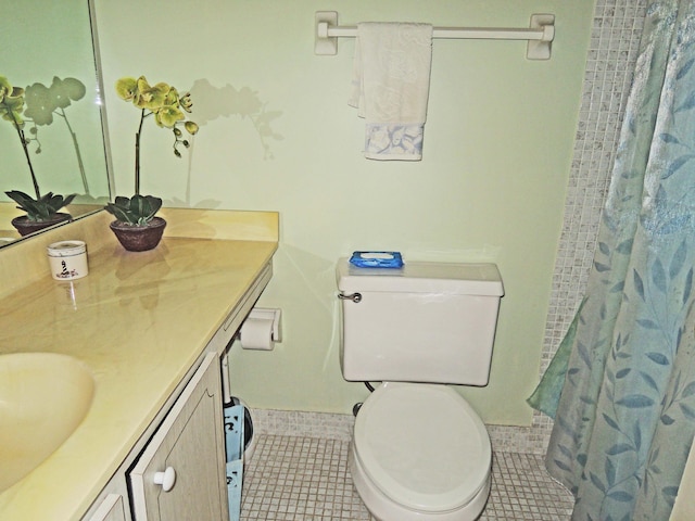 bathroom featuring toilet, tile floors, and vanity