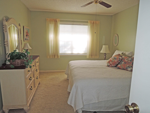 bedroom featuring light carpet, a textured ceiling, and ceiling fan