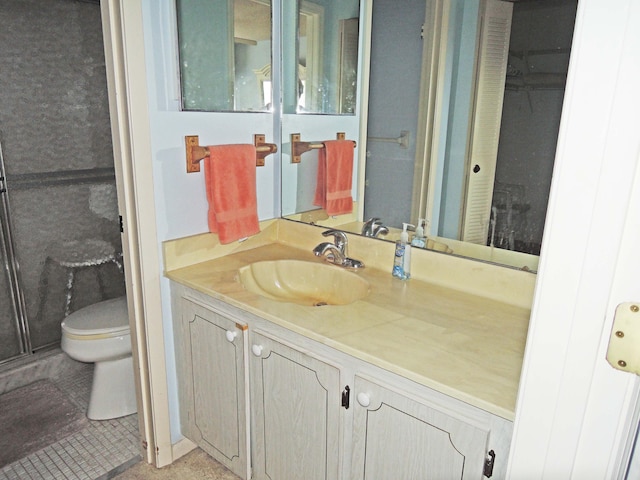 bathroom featuring tile floors, large vanity, and toilet