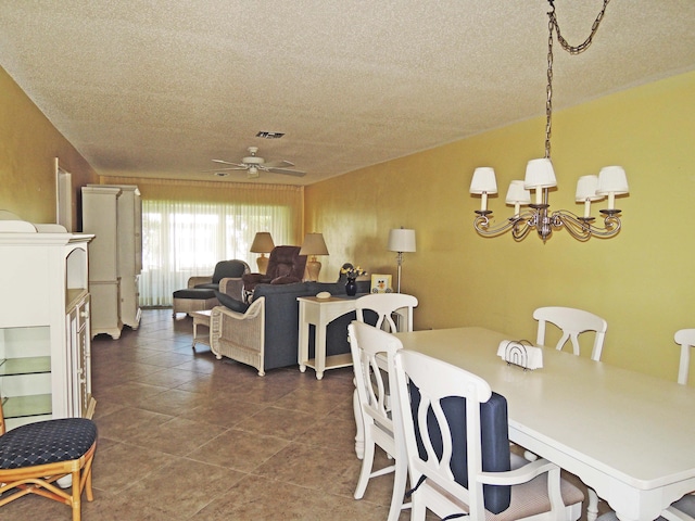 dining area with dark tile floors, ceiling fan, and a textured ceiling