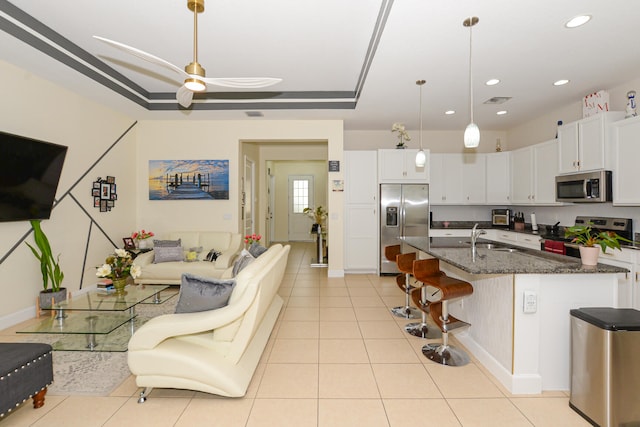 kitchen with white cabinets, decorative light fixtures, ceiling fan, and stainless steel appliances