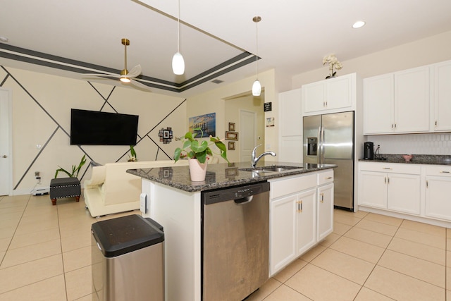 kitchen featuring an island with sink, ceiling fan, appliances with stainless steel finishes, white cabinets, and hanging light fixtures