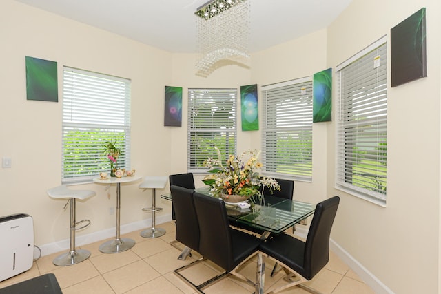 tiled dining room with plenty of natural light and a chandelier