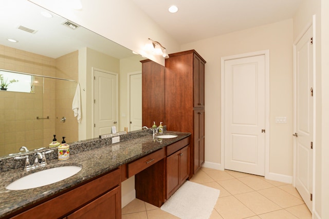 bathroom featuring double vanity, tile flooring, and tiled shower