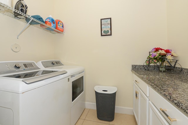 washroom featuring washer and dryer, light tile floors, and cabinets